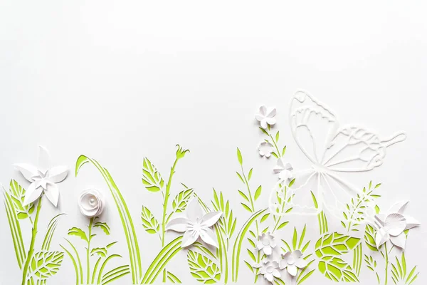 Summer flowering meadow. White flowers carved from paper on a white background with green leaves — Stock Photo, Image