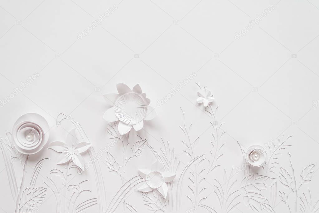 Summer flowering meadow. White flowers carved from paper on a white background