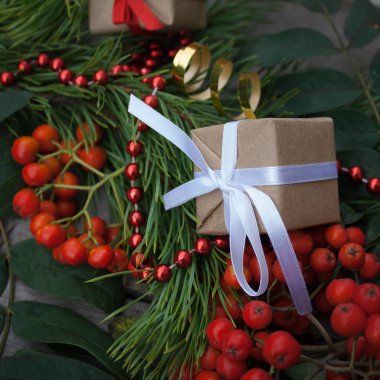 Noel hediye closeup dalları Ladin, kül ve kırmızı boncuk ahşap zemin üzerine