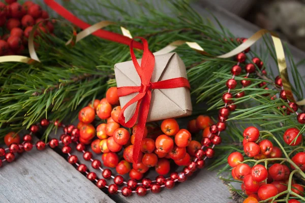 Noel hediye closeup dalları Ladin, kül ve kırmızı boncuk ahşap zemin üzerine