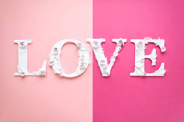 Foto inscripción amor hecho de hojas y flores sobre fondo rosa — Foto de Stock