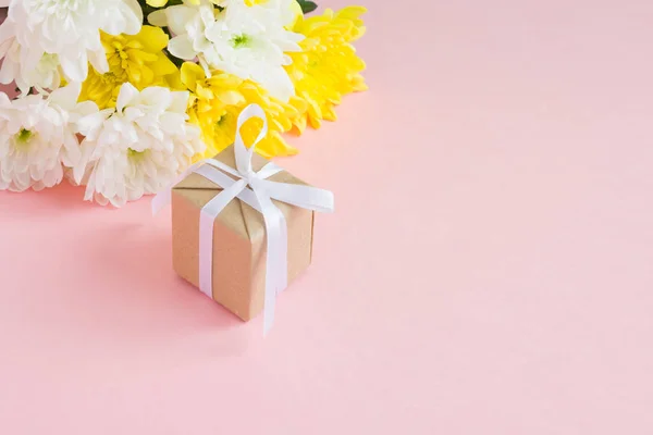 Ramo de crisantemos blancos y amarillos sobre un fondo rosa pálido — Foto de Stock