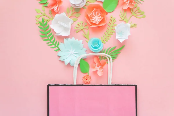 Bolsa de papel de diferentes flores de papel sobre un fondo rosa. Compras . — Foto de Stock