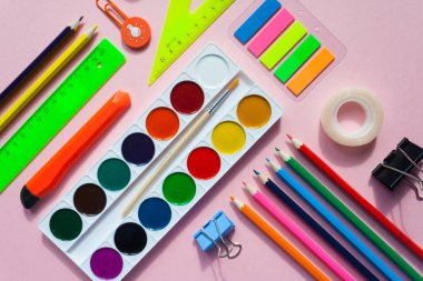 kare kare Kırtasiye üzerinde pembe bir arka plan ile. düz lay.