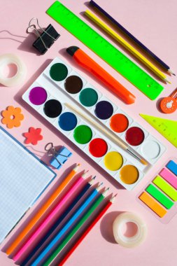 kare kare Kırtasiye üzerinde pembe bir arka plan ile. düz lay.