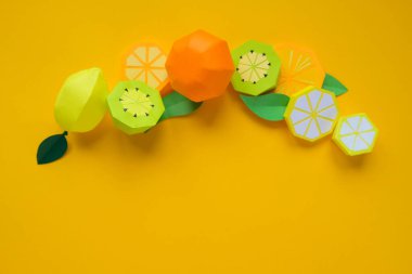 Kağıttan meyveler. Sarı arka plan. Yazmak için yer var. Tropik bölgeler.