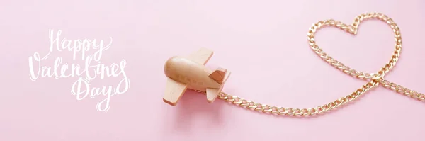 금속 체인에서 하트 모양으로 운반되는 작은 나무 장난감 비행기 — 스톡 사진