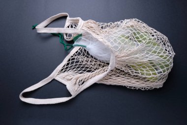 Siyah arka planda bir sicim torbasında kabaklı kompozisyon. Sıfır atık.