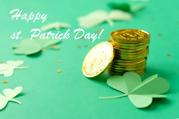 День Святого Патрика, клевер и золотые монеты на зеленом фоне — стоковое фото
