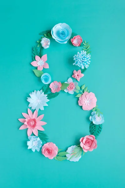 The number 8 is made of flowers cut from paper on a mint background