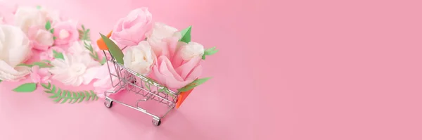 Ciao, primavera. Carrello con fiori di carta bianca e rosa e foglie verdi — Foto Stock