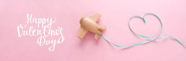 Small wooden toy airplane lucky with red ribbon in the shape of heart — 스톡 사진