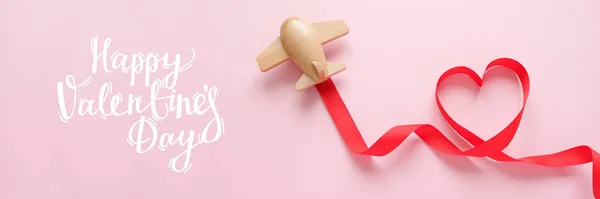 Mały drewniany samolot zabawki szczęśliwy z czerwoną wstążką w kształcie serca — Zdjęcie stockowe
