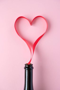 Heart of red ribbon on pink background