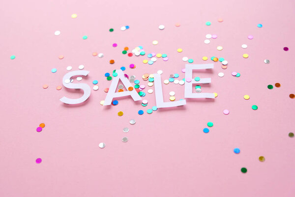 Продажа с красочными конфетти на розовом фоне
