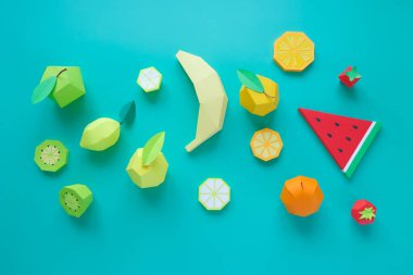 Different exotic fruits made of paper on trendy mint background