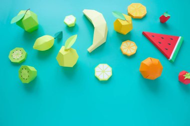 Different exotic fruits made of paper on trendy mint background