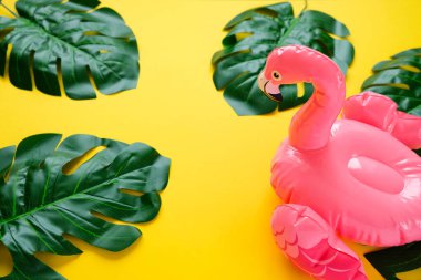 Sarı arka planda şişirilebilir pembe flamingolar.