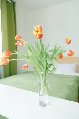 Yatak odasındaki kırmızı sarı lalelerden oluşan bir buket. Aşk konsepti