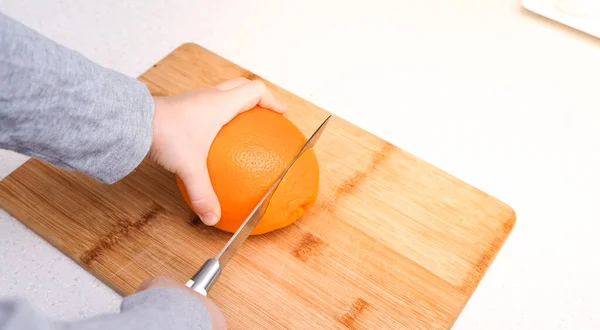 Mãos Menino Cortaram Uma Laranja Uma Tábua Corte Cozinha — Fotografia de Stock