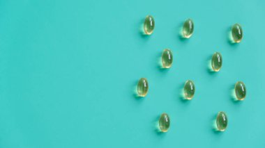 Mavi arka planda balık yağı kapsülleri. Beriberi, bağışıklık sistemini güçlendiriyor. Desen