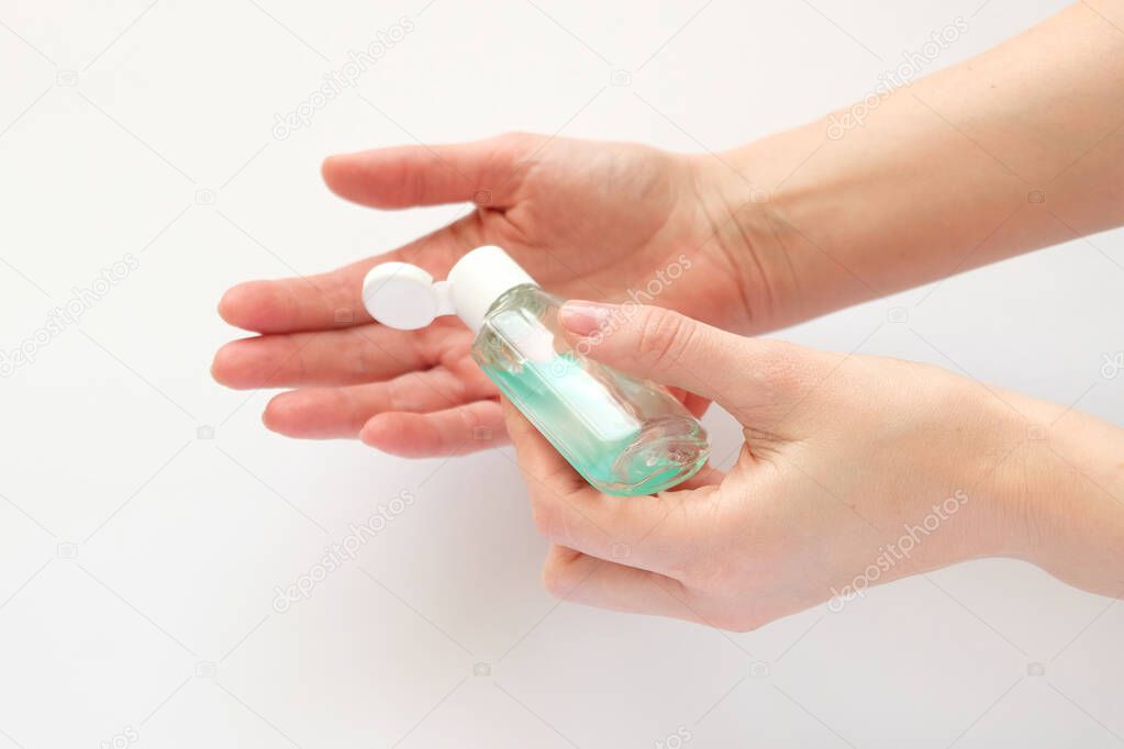 Bottle with antibacterial antiseptic gel in hand on white. Hand hygiene, sanitizer. Pandemic Covid-19
