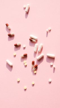 Pembe arka planda çeşitli ilaç hapları, haplar ve kapsüller var. Kavram salgını, koronavirüs 2019