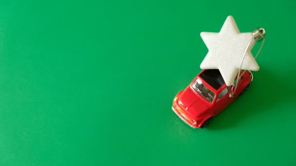 Coche rojo lleva un juguete árbol de Navidad, un símbolo del año nuevo — Vídeo de stock