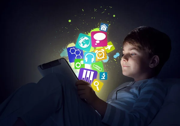 Boy with tablet in his bed — Stock Photo, Image