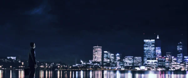 Empresario viendo la noche brillante ciudad — Foto de Stock