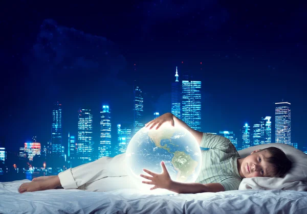 Boy in bed with glowing Earth — ストック写真