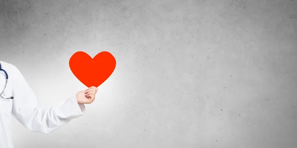 Doctor holding red heart — Stock Photo, Image