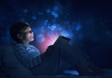 Çocuk onun yatakta tablet ile