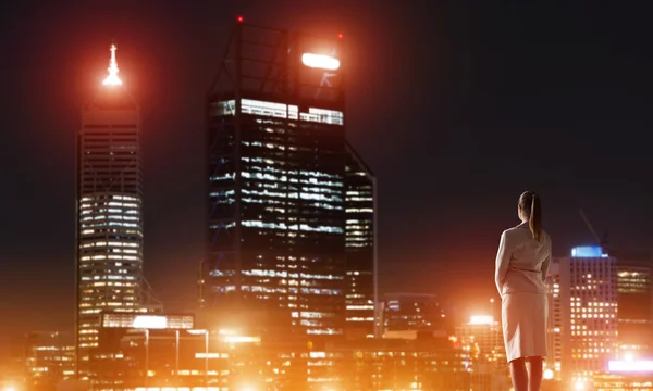 Mujer mirando la ciudad nocturna — Foto de Stock