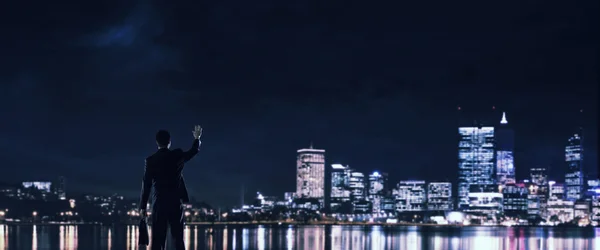 Gece parlayan city ile ilgilenen iş adamı — Stok fotoğraf