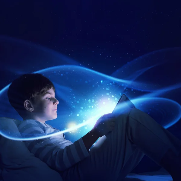 Boy with tablet in his bed — Stock Photo, Image