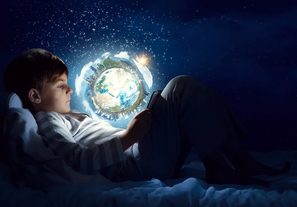 Boy with tablet in his bed — Stock Photo, Image