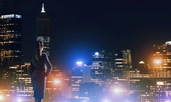 Vrouw kijken naar nacht stad — Stockfoto