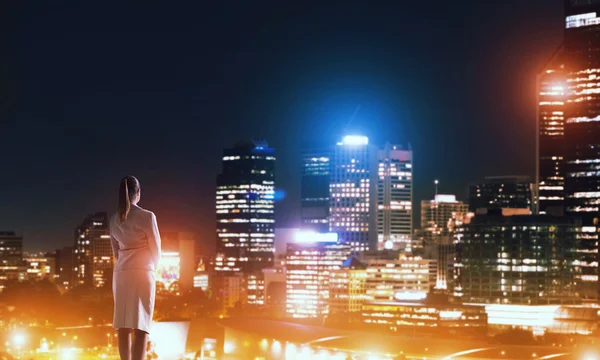 Mujer mirando la ciudad nocturna — Foto de Stock