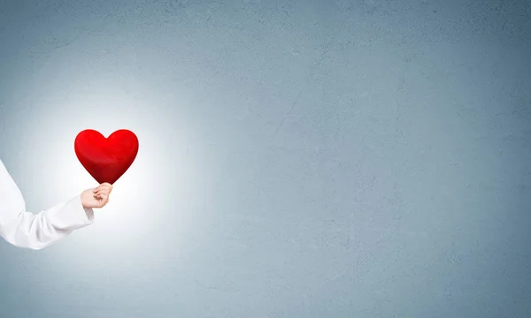 Doctor holding red heart — Stock Photo, Image