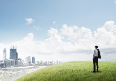 Tepenin üstünde duran işadamı 