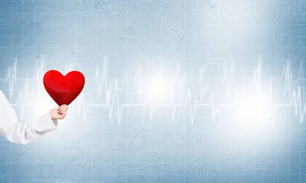 Доктор держит красное сердце — стоковое фото