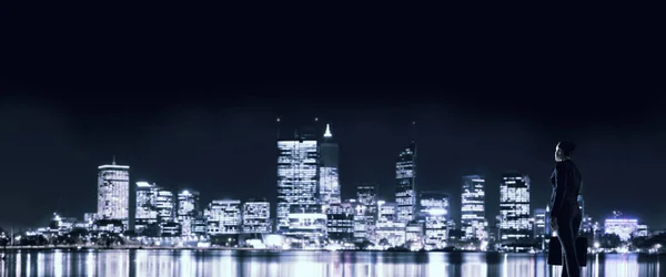 Geschäftsfrau sieht Nacht glühende Stadt — Stockfoto