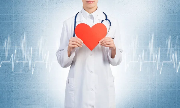 Jovem médico segurando coração vermelho — Fotografia de Stock