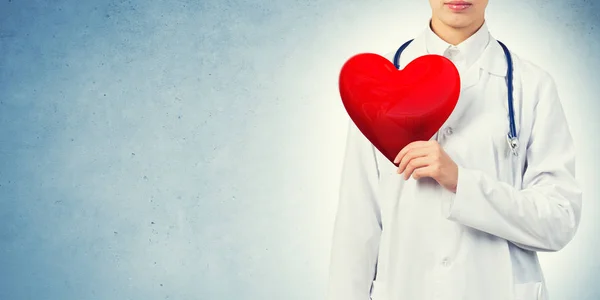 Giovane donna medico in possesso di cuore rosso — Foto Stock