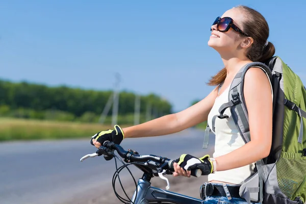 Frau mit Rucksack auf Fahrrad unterwegs — Stockfoto