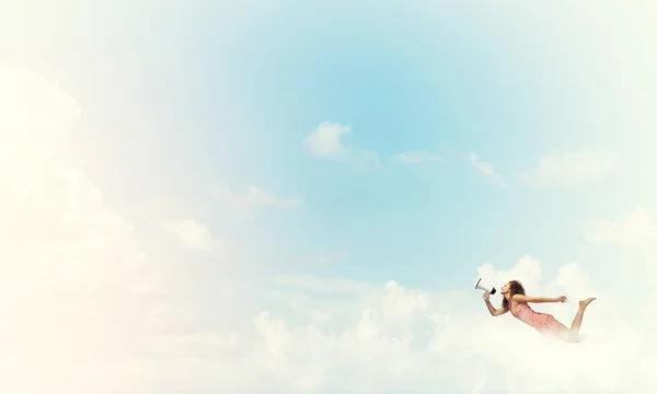 Женщина с мегафоном летит — стоковое фото