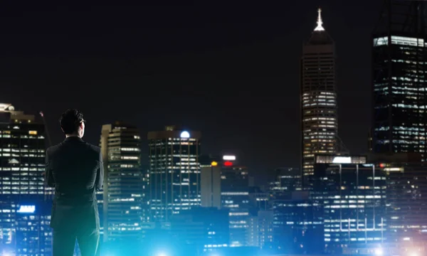 Podnikatel, zobrazení noci zářící město — Stock fotografie