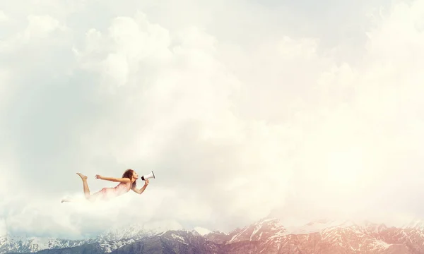 Woman with megaphone flying — Stock Photo, Image