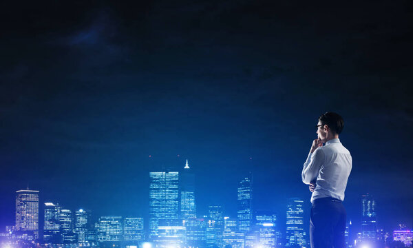 Businessman viewing night glowing city